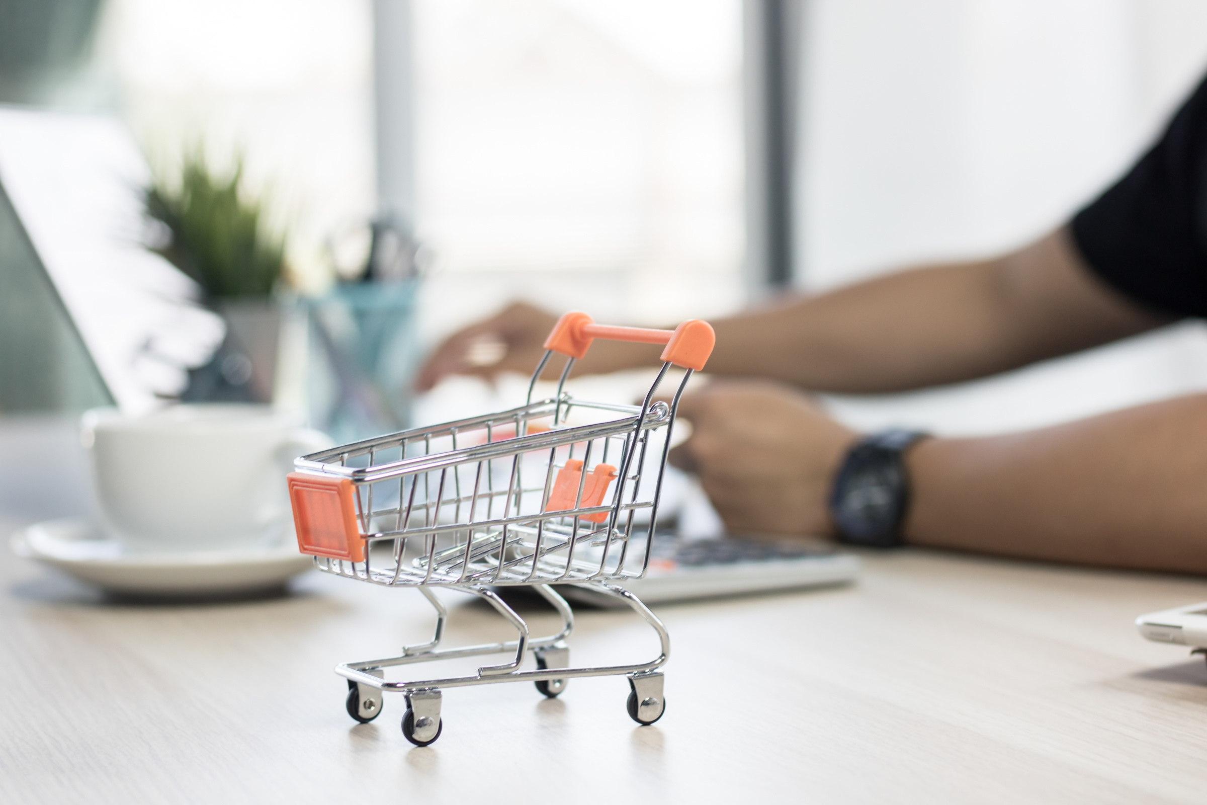 Shopping Cart and on Table with People Pressing on Notebook for